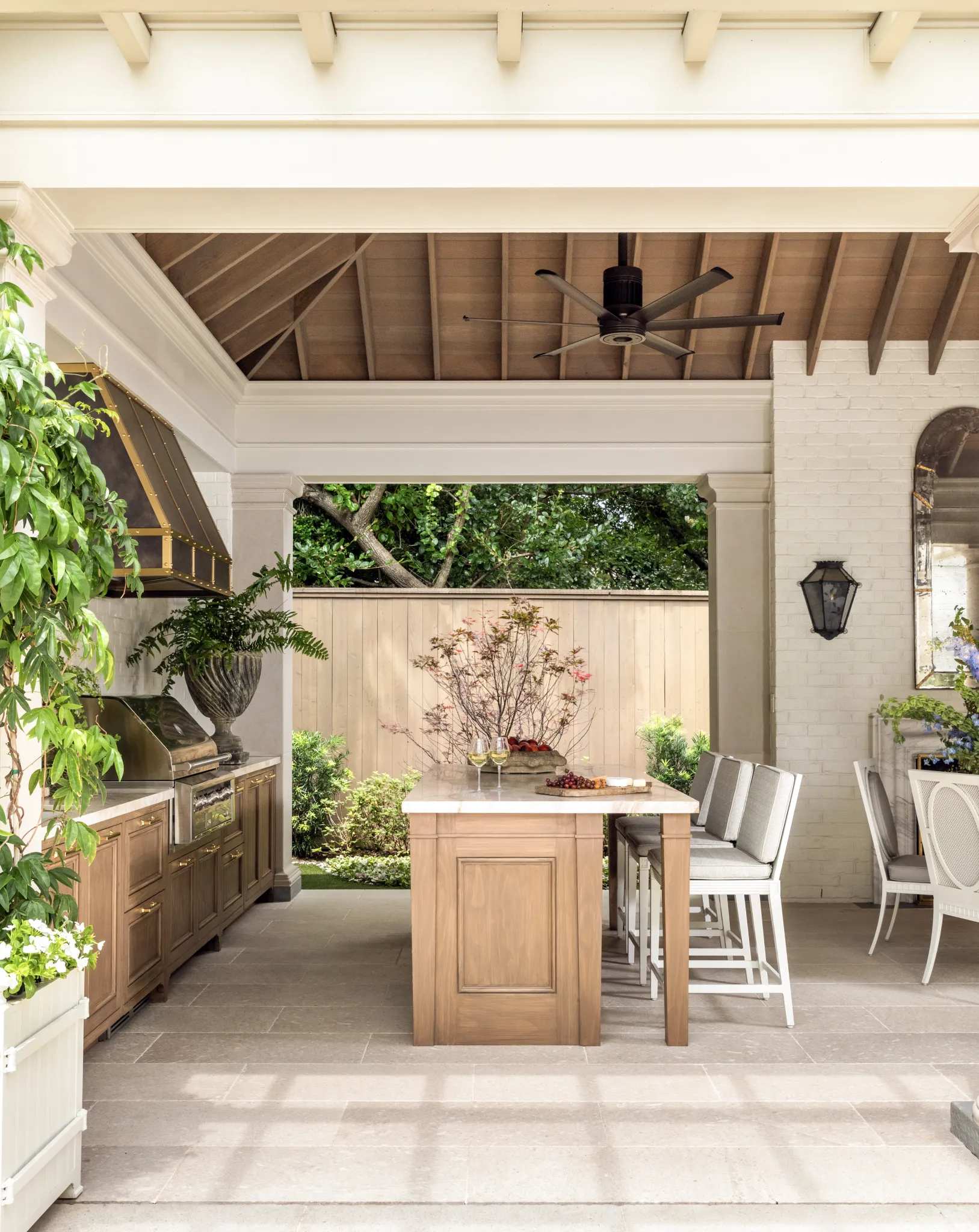 Kitchen island centered under a vaulted wood ceiling, looking out to the garden